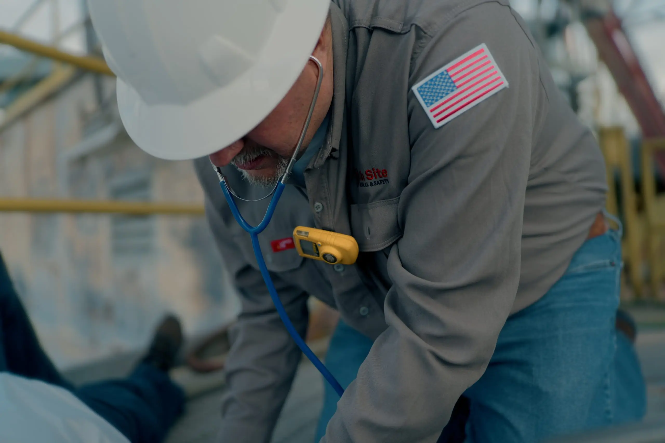 An On Site medic with stethoscope tending to a worker on the rig